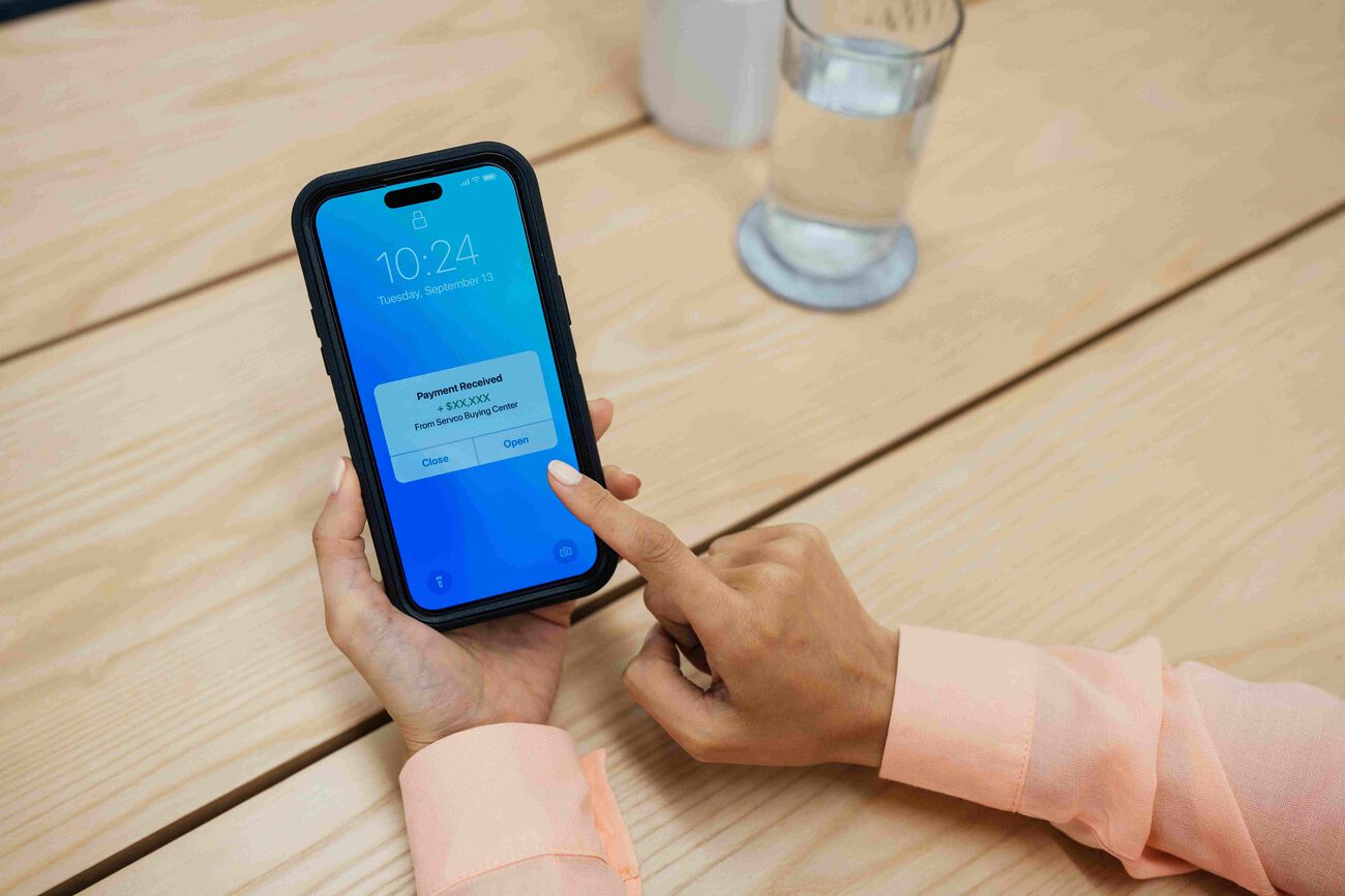 The mover person receives a payment on their phone after selling their car.